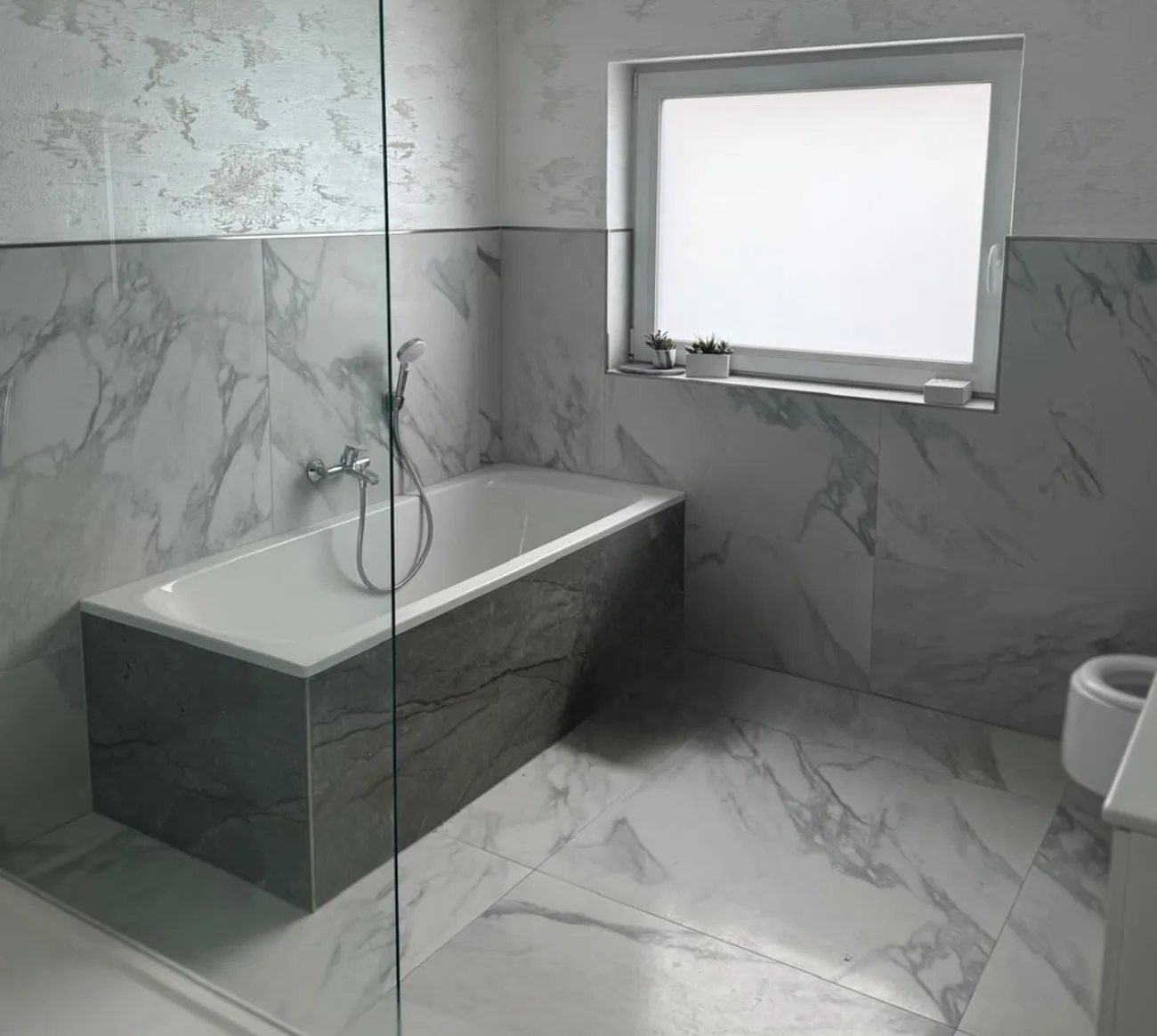 Neu saniertes Bad mit Wanne, Glaswand und Marmorfliesen